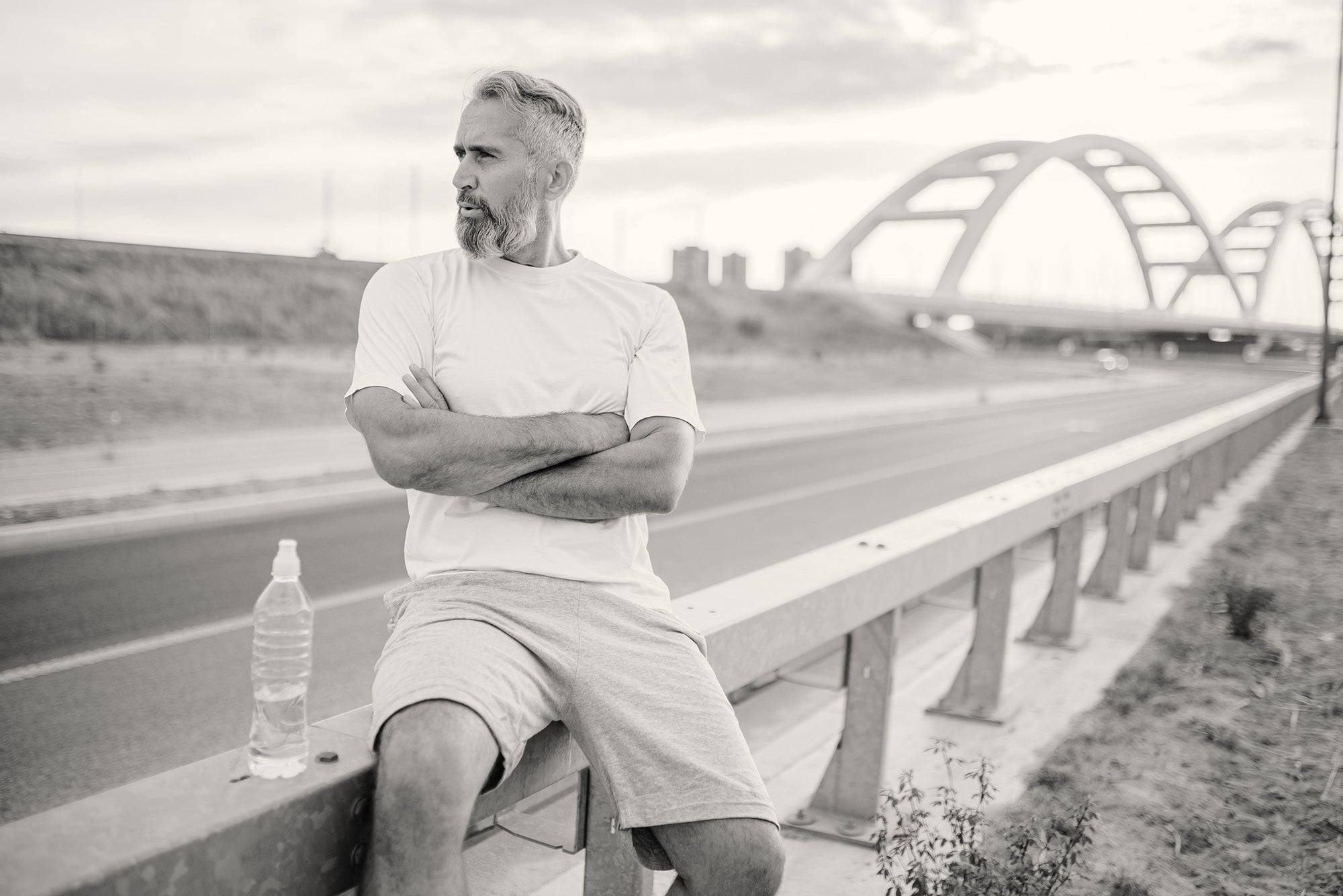 Older man sitting by side of road